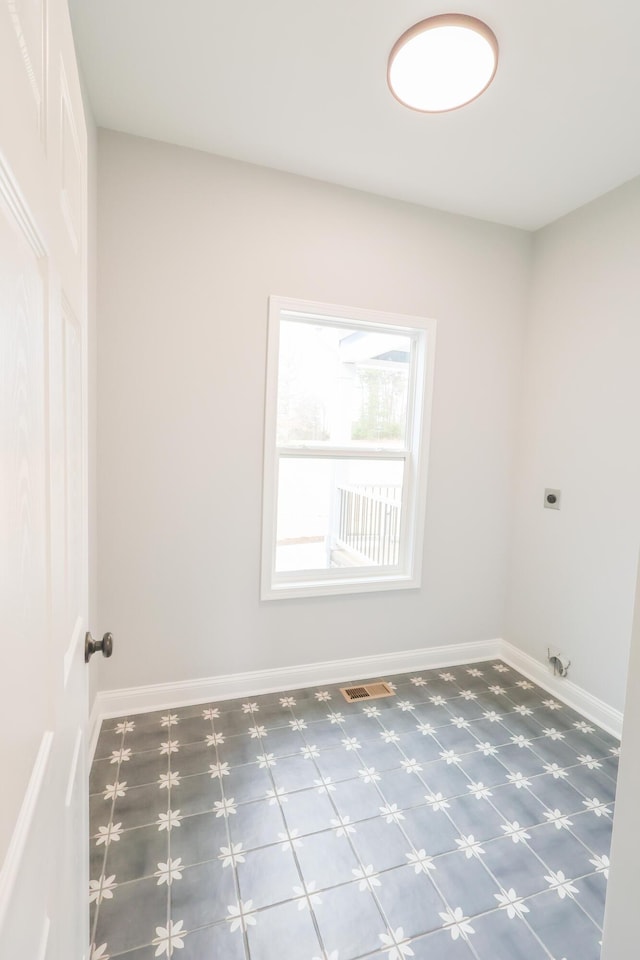 clothes washing area featuring laundry area, baseboards, visible vents, and hookup for an electric dryer