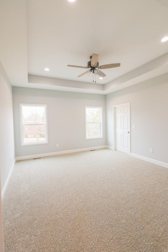 spare room featuring carpet, baseboards, a tray ceiling, and recessed lighting