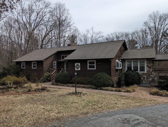 view of front of house featuring roof with shingles and a chimney