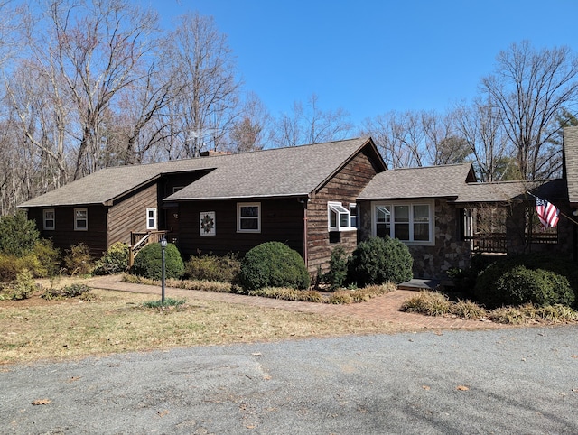 view of front of property featuring a chimney and a shingled roof