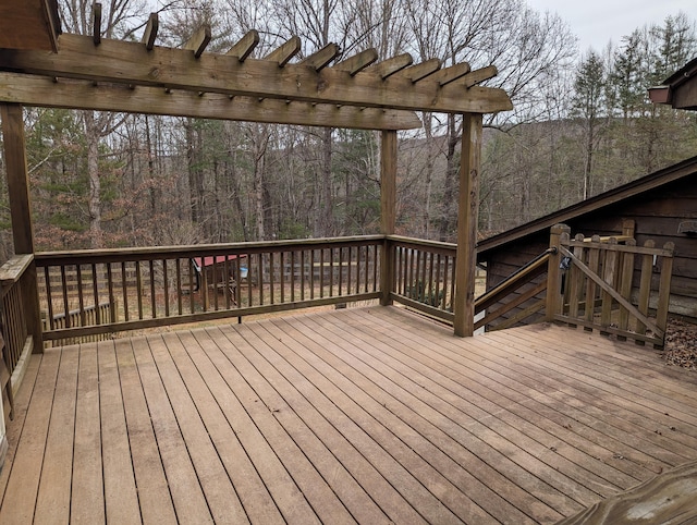 deck with a view of trees and a pergola