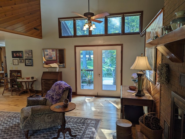 interior space with french doors, a fireplace, a high ceiling, and wood finished floors