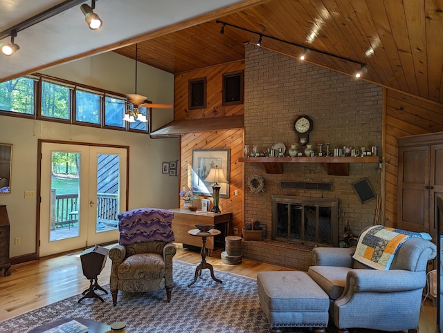 living room featuring a brick fireplace, wood ceiling, wood walls, and wood finished floors