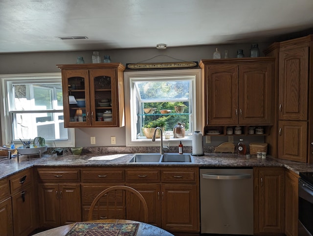 kitchen featuring a sink, visible vents, stainless steel dishwasher, brown cabinets, and glass insert cabinets