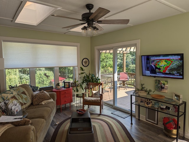 living room featuring a skylight, ceiling fan, and wood finished floors