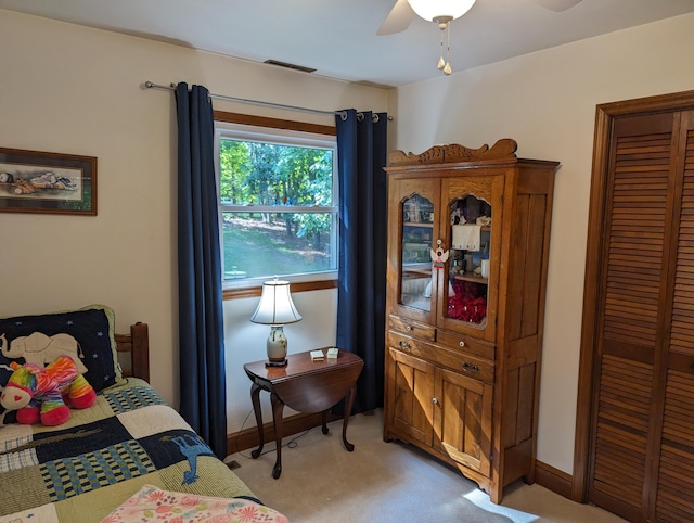 bedroom with a closet, visible vents, light carpet, ceiling fan, and baseboards