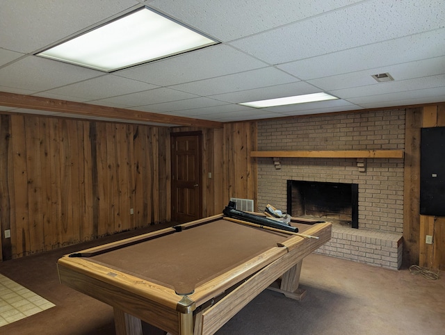 game room with wood walls, billiards, a brick fireplace, and a drop ceiling