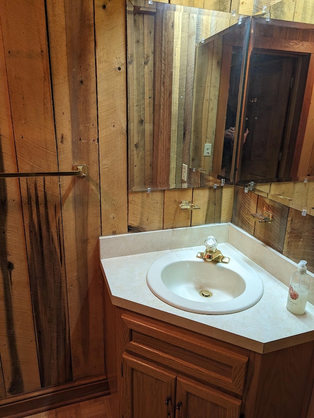 bathroom with vanity and wooden walls