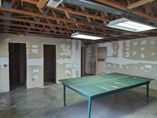 game room with unfinished concrete flooring