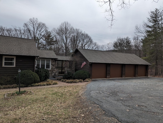 view of front of house with a garage and roof with shingles