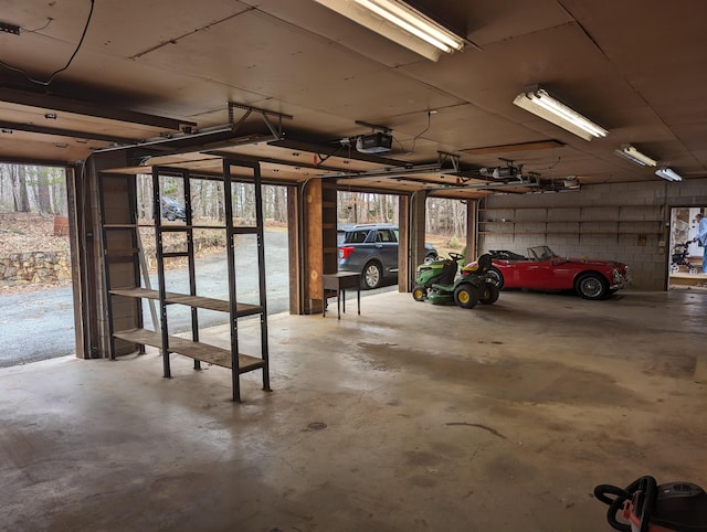 garage featuring concrete block wall and a garage door opener