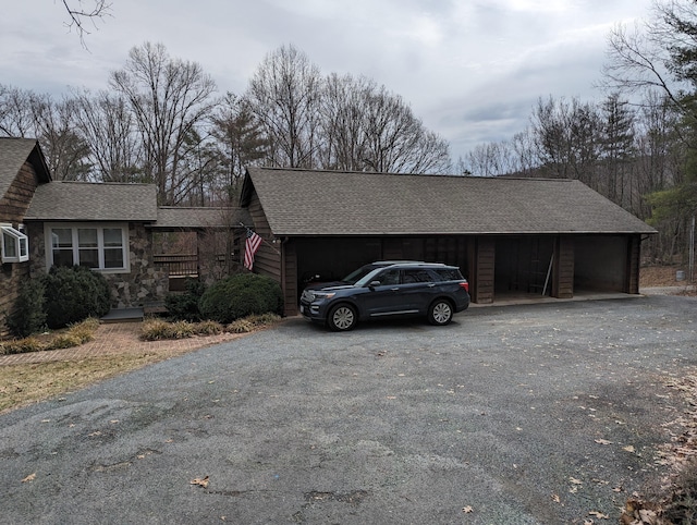 view of home's exterior with a garage, stone siding, and roof with shingles