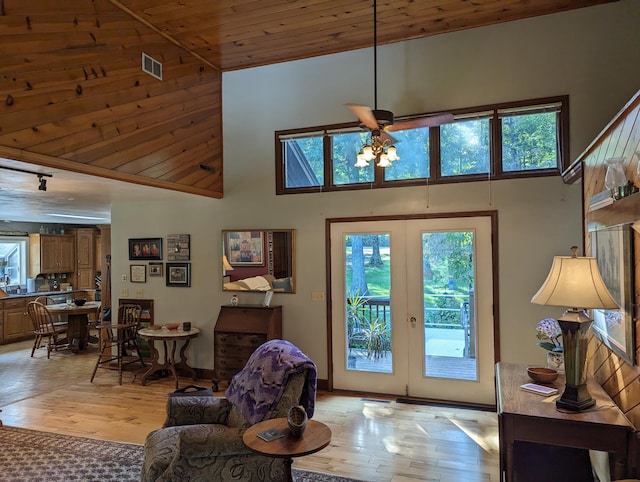 entryway featuring french doors, wooden ceiling, a towering ceiling, and light wood-style flooring