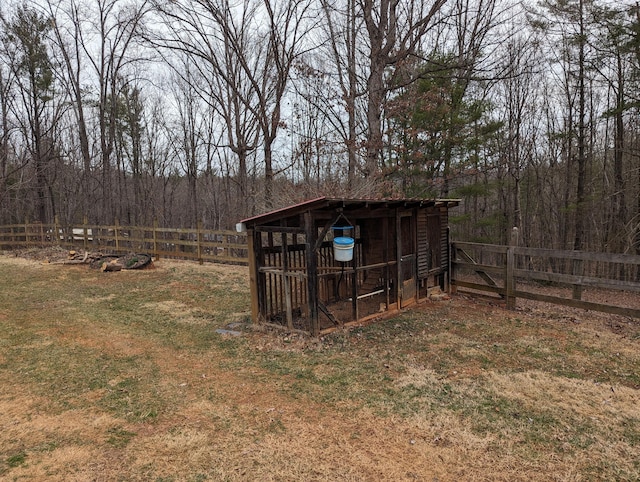 view of poultry coop featuring fence and a forest view