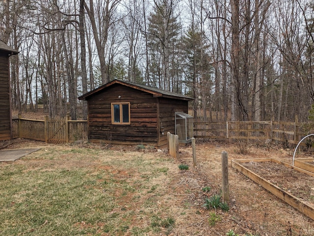 exterior space with an outbuilding, a garden, and fence