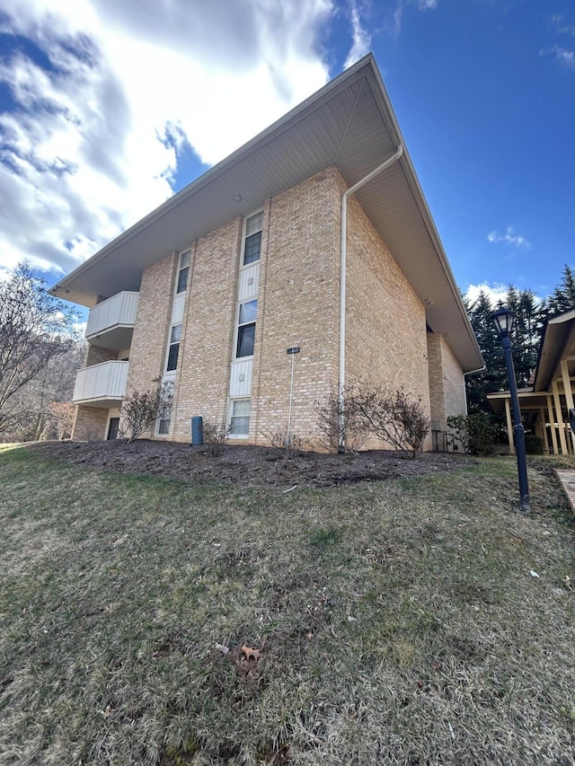 view of home's exterior with a yard and brick siding