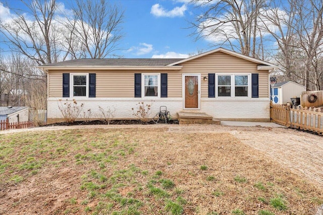 single story home with brick siding, a front yard, and fence