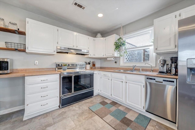 kitchen with open shelves, visible vents, appliances with stainless steel finishes, a sink, and under cabinet range hood