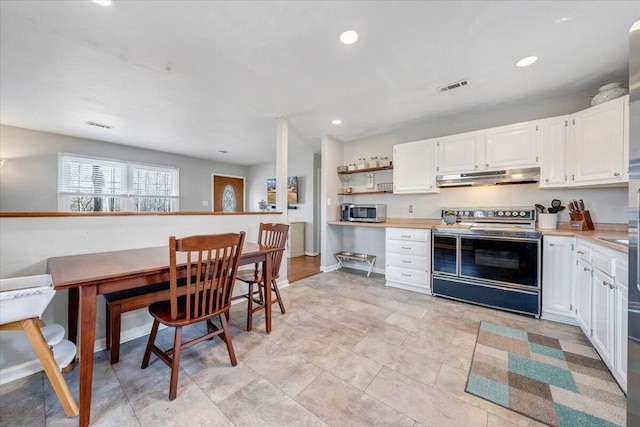 kitchen with light countertops, visible vents, stainless steel microwave, electric range oven, and under cabinet range hood