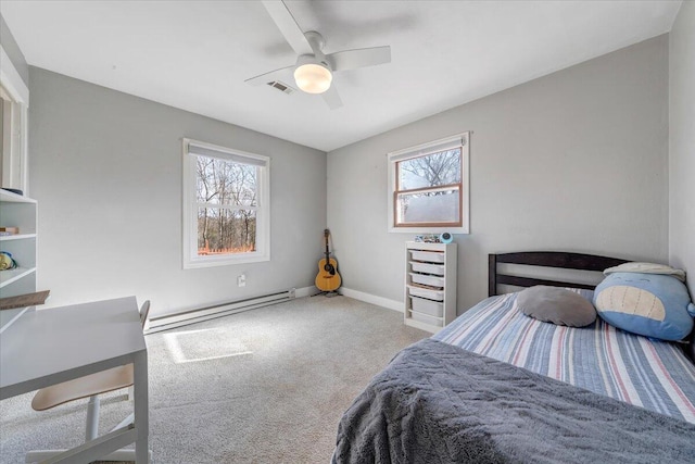 bedroom with a baseboard heating unit, multiple windows, visible vents, and carpet flooring