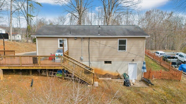 rear view of property with stairs, fence, and a wooden deck