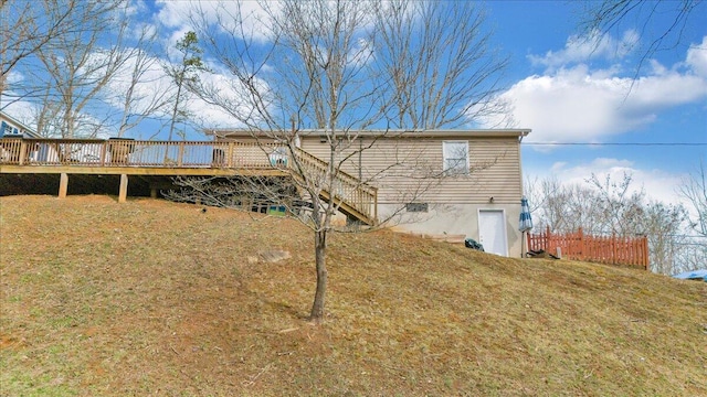 back of house featuring a yard, a deck, and fence