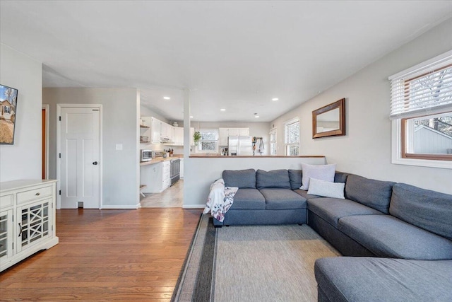 living area with dark wood-style floors, recessed lighting, and baseboards