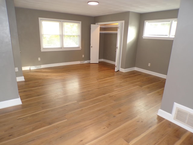 unfurnished bedroom featuring light wood finished floors, baseboards, and visible vents