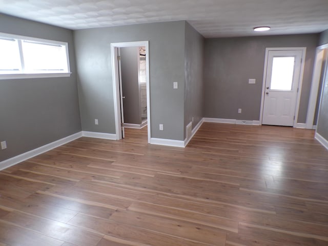 unfurnished room with baseboards and wood finished floors