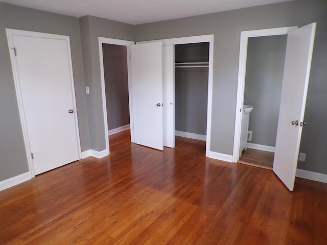 unfurnished bedroom with a closet, baseboards, and wood finished floors