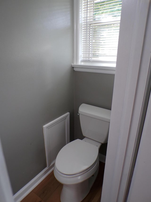 bathroom featuring toilet, baseboards, and wood finished floors