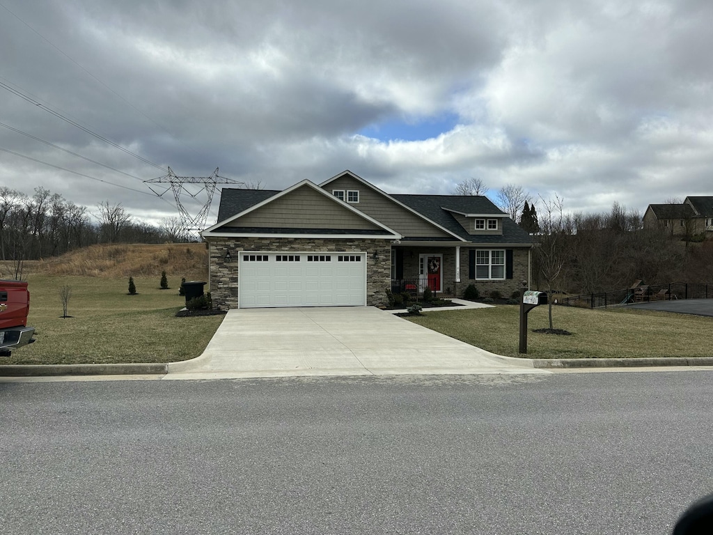 craftsman house with a garage, concrete driveway, stone siding, and a front yard