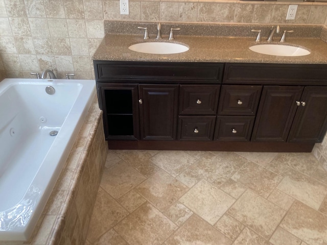 full bathroom with a whirlpool tub, double vanity, and a sink