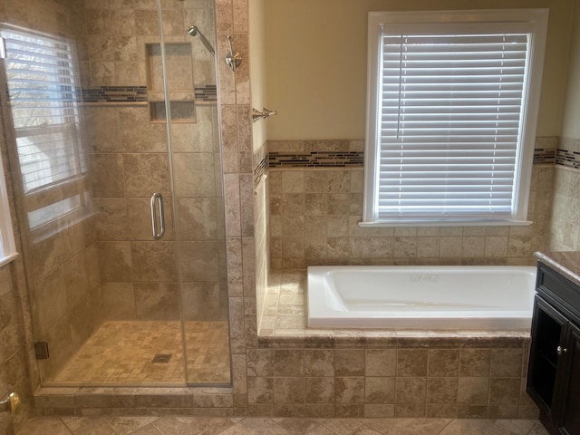 bathroom featuring a shower stall, a bath, and vanity