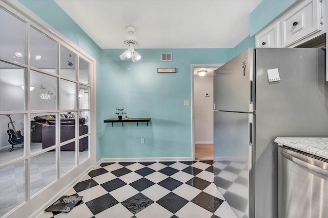 kitchen featuring dark floors, stainless steel appliances, visible vents, white cabinets, and baseboards