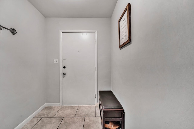 doorway to outside with baseboards and light tile patterned floors