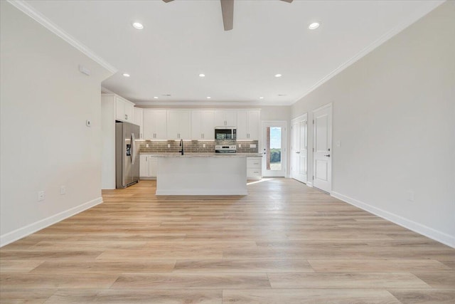 kitchen featuring white cabinets, ceiling fan, appliances with stainless steel finishes, crown molding, and backsplash