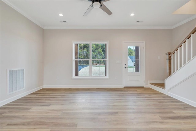 entryway with crown molding, visible vents, light wood-style floors, and stairs