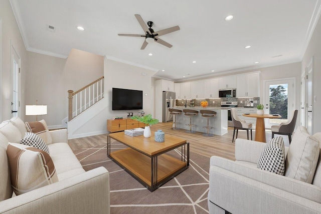 living room featuring recessed lighting, ceiling fan, light wood finished floors, and stairway