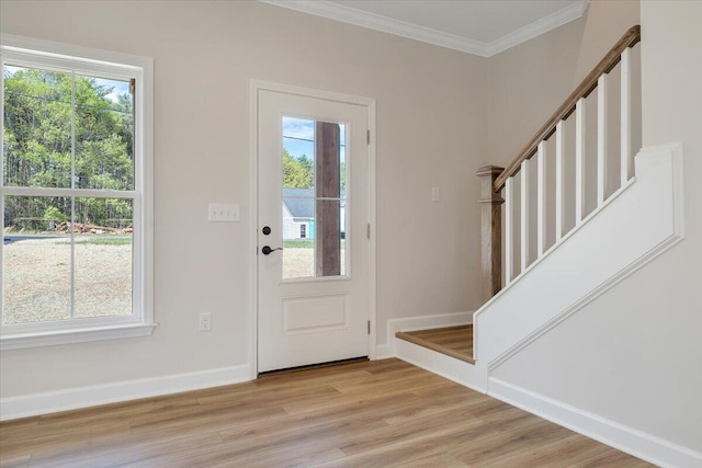 entryway featuring crown molding, light wood finished floors, baseboards, and stairs