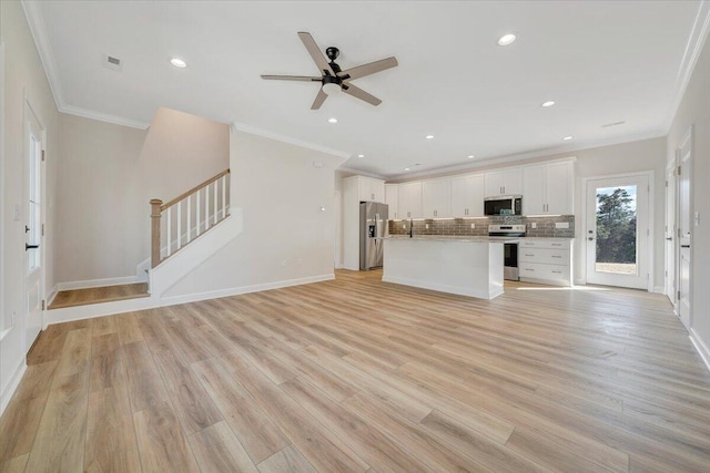 unfurnished living room with recessed lighting, ceiling fan, ornamental molding, and stairway