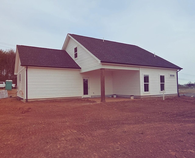 back of house with roof with shingles