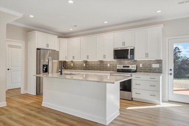 kitchen featuring a sink, tasteful backsplash, appliances with stainless steel finishes, and white cabinetry