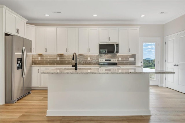kitchen featuring white cabinetry, ornamental molding, appliances with stainless steel finishes, a sink, and decorative backsplash