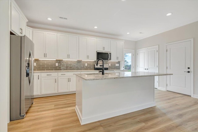 kitchen with tasteful backsplash, light wood-style flooring, white cabinetry, and appliances with stainless steel finishes