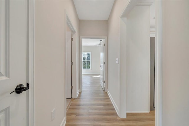 hallway with light wood-style floors and baseboards