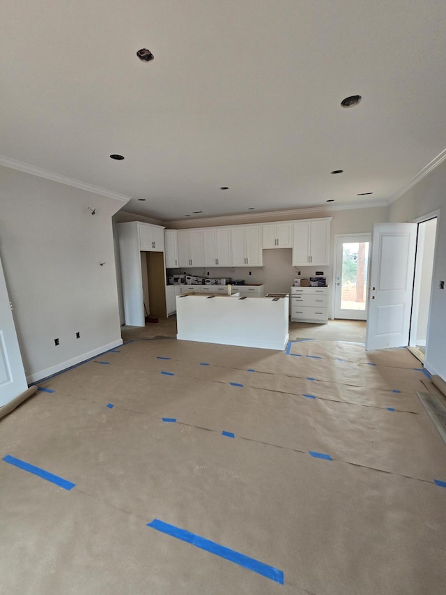 unfurnished living room with ornamental molding and baseboards