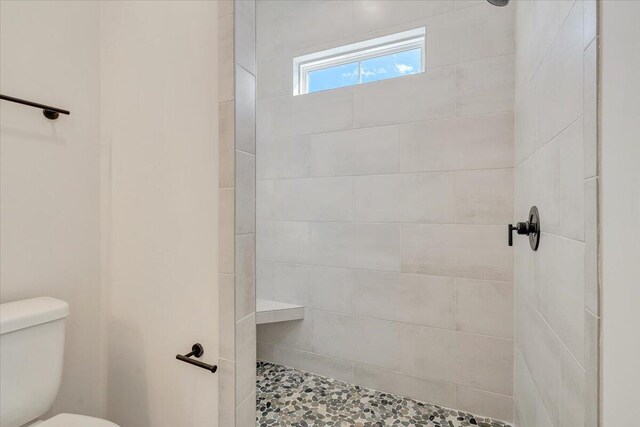 full bath featuring toilet and tiled shower