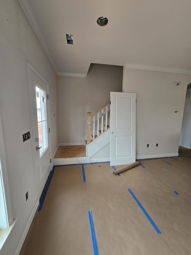 foyer entrance featuring stairs, ornamental molding, and baseboards