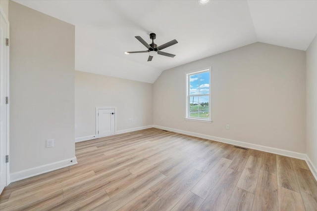 additional living space featuring light wood-style floors, visible vents, vaulted ceiling, and ceiling fan
